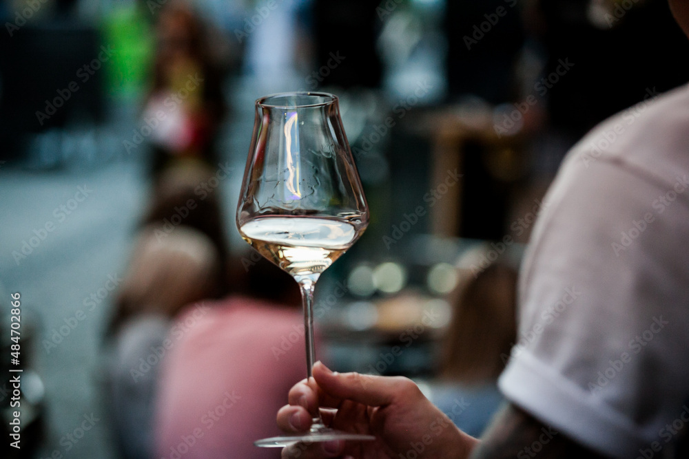 wine glass in the male sommelier's hand. Wine bar or winery. degustation.