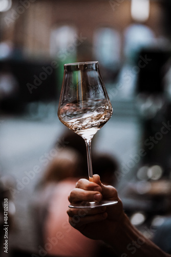 wine glass in the male sommelier's hand. Wine bar or winery. degustation.