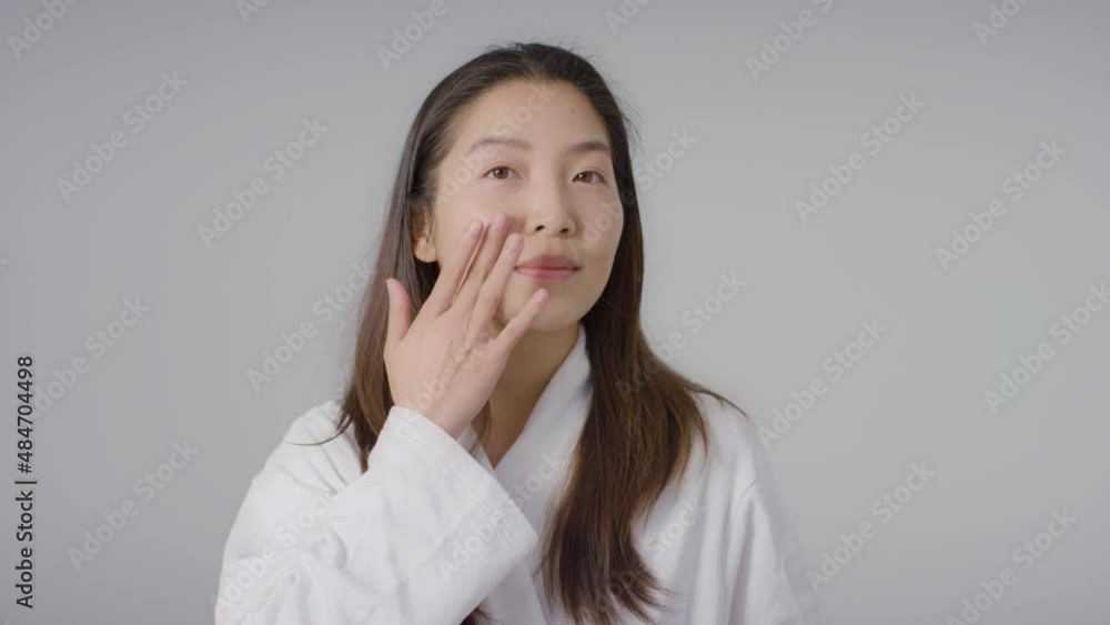 Mid Shot of a Young Woman Applying Foundation Mid Shot of a Young Woman Applying Foundation