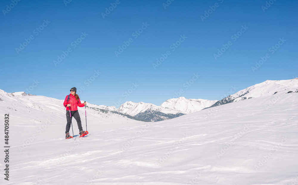 Woman practicing winter sports. Snowshoeing on a sunny day Woman practicing winter sports. Snowshoeing on a sunny day