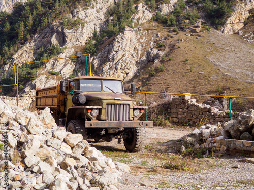 Old truck stands against the background of mountains