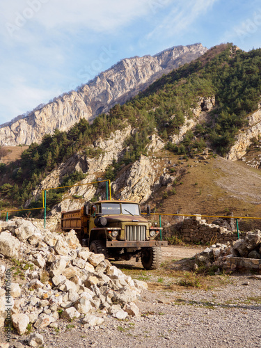 Old truck stands against the background of mountains