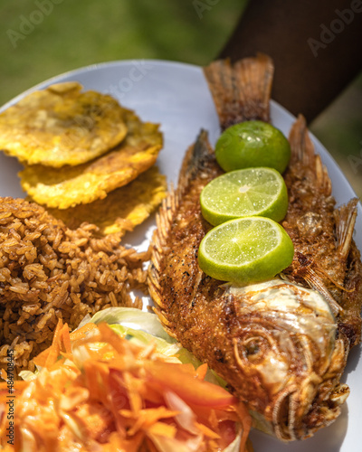 pescado frito, toston, comida tradicional de la costa colombiana, comida deliciosa, en platos blancos con fondos de madera. fideos a la pescadora, todo sobre la costa.