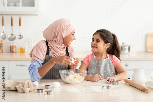 Leisure With Mom. Happy Muslim Mother And Little Daughter Baking In Kitchen