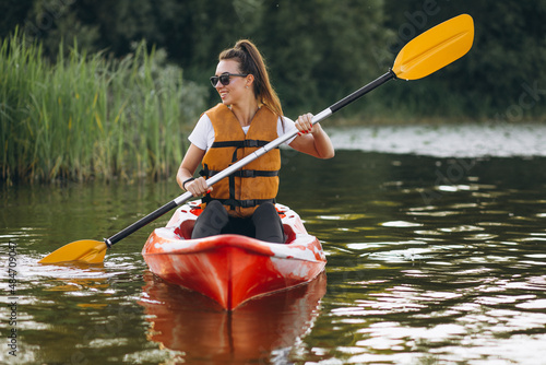 Young woman kayaking on the lake