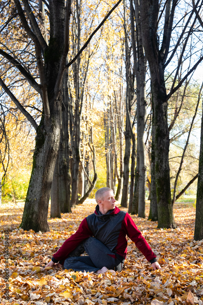 Sporty man practicing yoga in autumn park Sporty man practicing yoga in autumn park