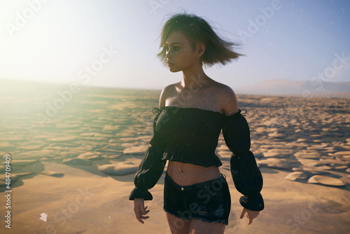 Tablou pe pânză Blond woman with wind in her hair in a black shirt in a sunny desolate dry landscape