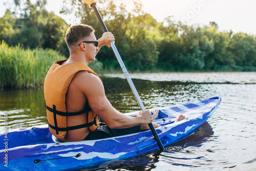 Young man kayaking on the river