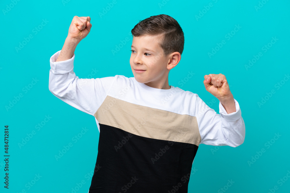 Little kid boy isolated on blue background doing strong gesture Little kid boy isolated on blue background doing strong gesture
