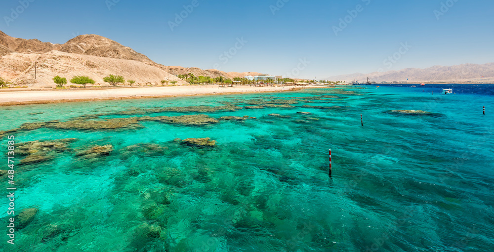 Beautiful coral reefs of the Red Sea, sandy beaches, small tourist hotels and Sinai mountains near Eilat – famous tourist resort and recreational city in Israel.