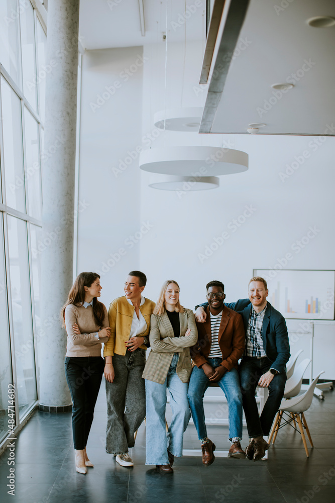 Fototapeta premium Group of positive businesspeople standing together in the office