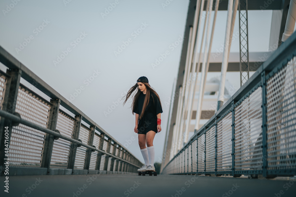 Young woman riding her longboard on the bridge Young woman riding her longboard on the bridge