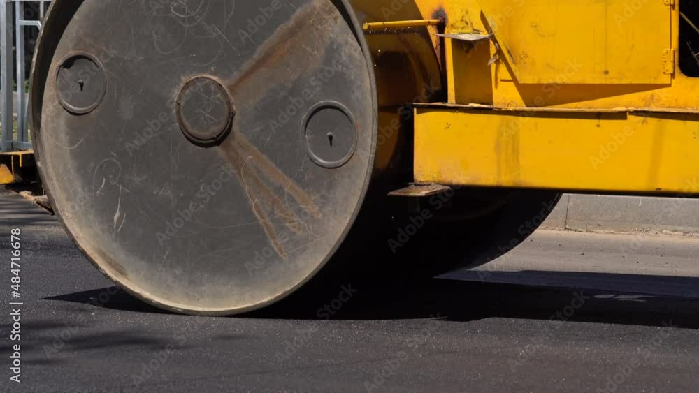 The paver mover on a flat newly made road, ramming and leveling. Asphalt paver applying asphalt on the repaired city road. The paver mover on a flat newly made road, ramming and leveling. Asphalt paver applying asphalt on the repaired city road.