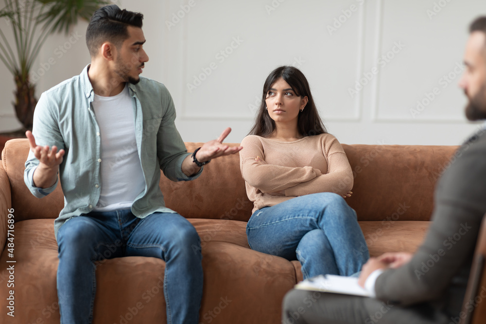 Couple talking at therapy session with male therapist Couple talking at therapy session with male therapist