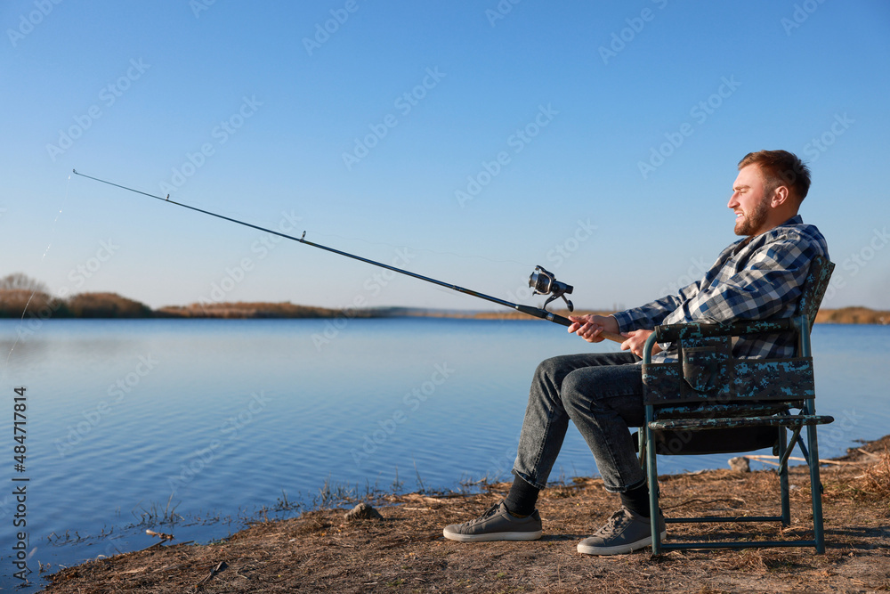 Fisherman with rod fishing at riverside. Recreational activity Fisherman with rod fishing at riverside. Recreational activity