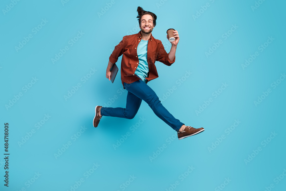 Full body profile photo of cool brunet millennial guy run with laptop cup wear eyewear shirt pants shoes isolated on blue background Full body profile photo of cool brunet millennial guy run with laptop cup wear eyewear shirt pants shoes isolated on blue background