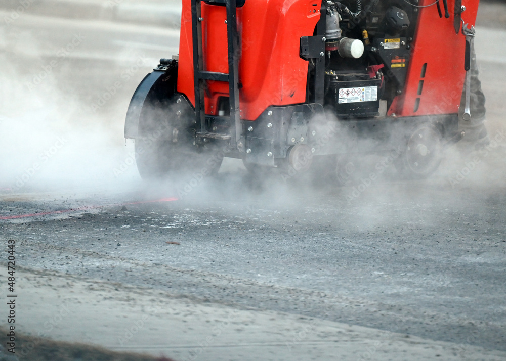 Asphalt saw cutting machine closeup with smoke Asphalt saw cutting machine closeup with smoke