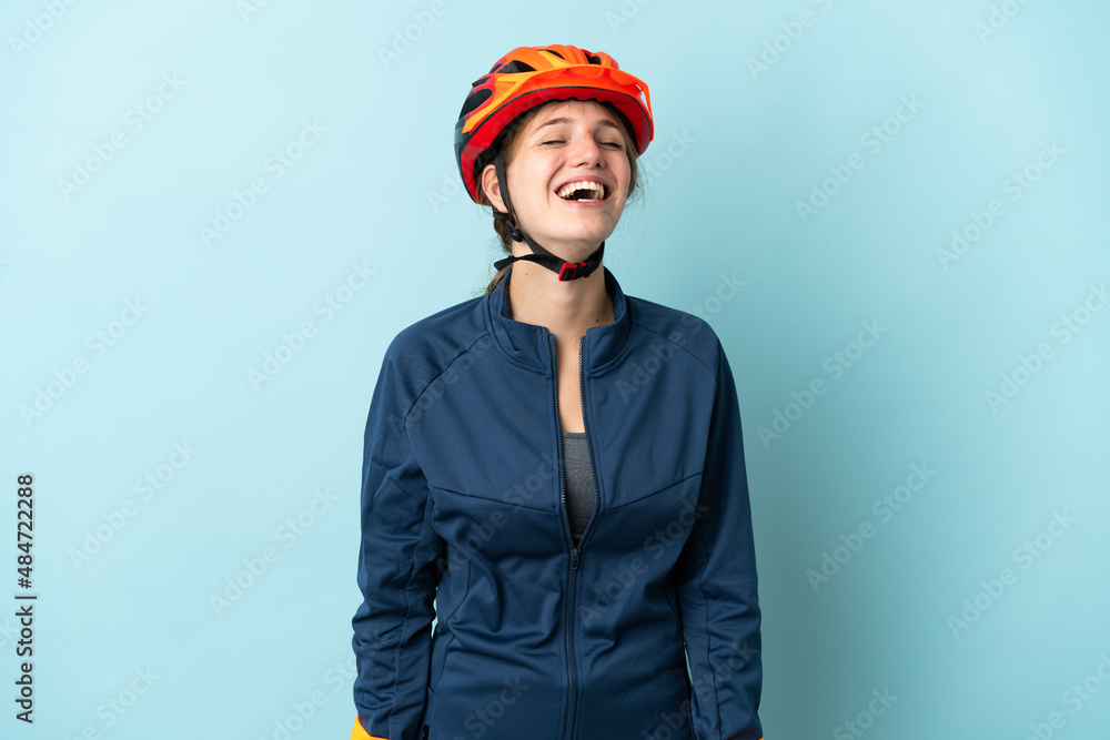 Young cyclist woman isolated on blue background laughing - obrazy, fototapety, plakaty 