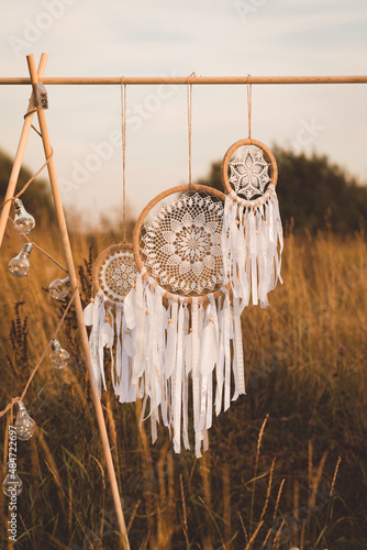 White cotton dreamcatcher at natural background, soft selective focus, toned