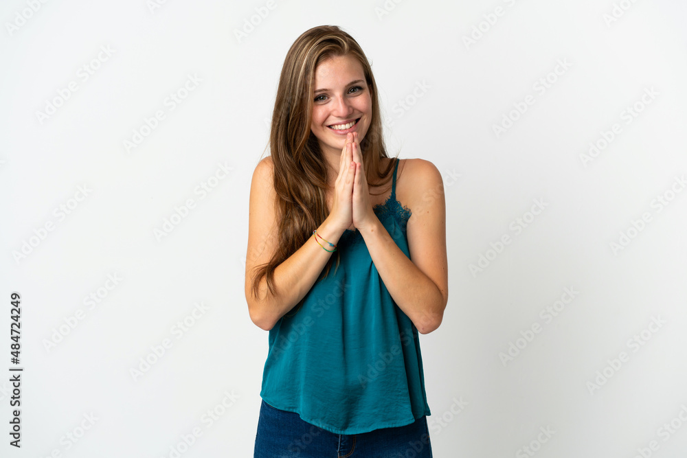 Young caucasian woman over isolated background keeps palm together. Person asks for something Young caucasian woman over isolated background keeps palm together. Person asks for something