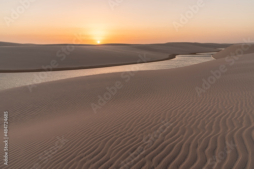 Beautiful sunset view to rainwater lagoon and sand texture on dunes