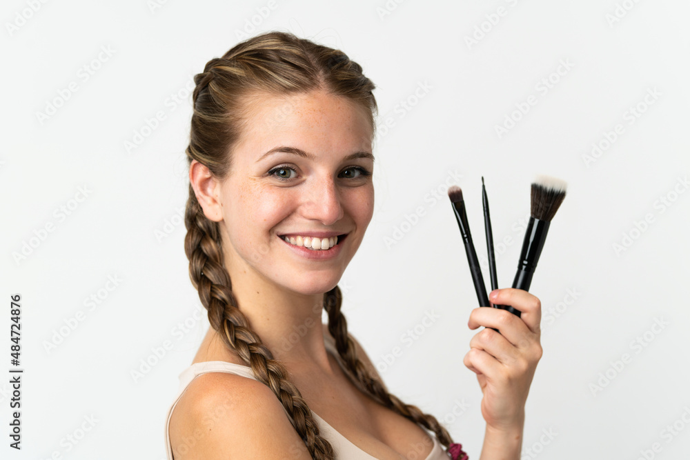 Young caucasian woman isolated on white background holding makeup brush