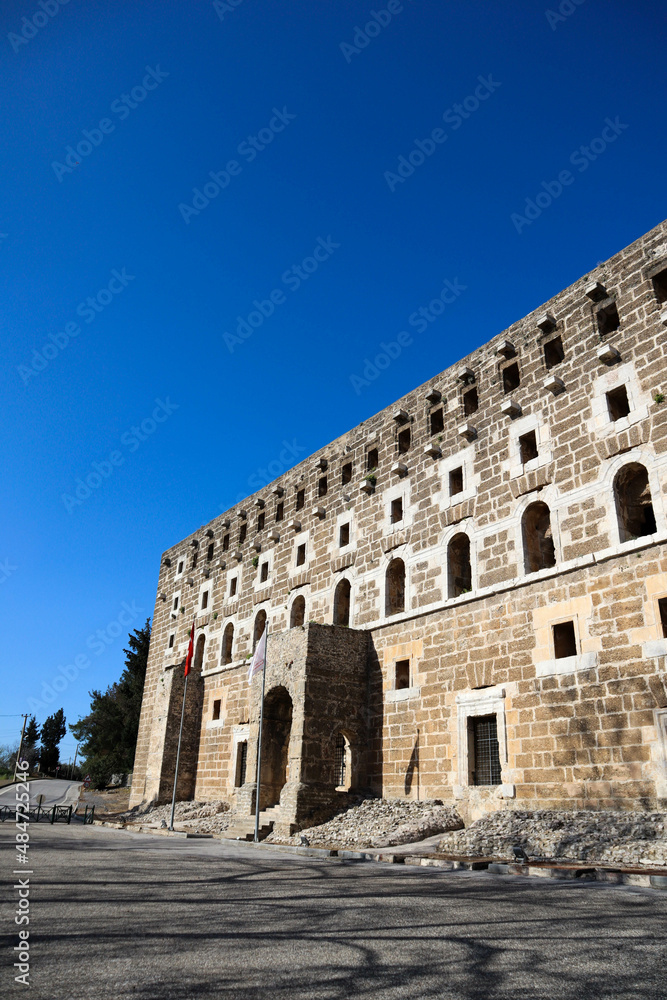 facade of majestic and well preserved Roman theatre in ancient city Aspendos, Turkey under blue spring sky