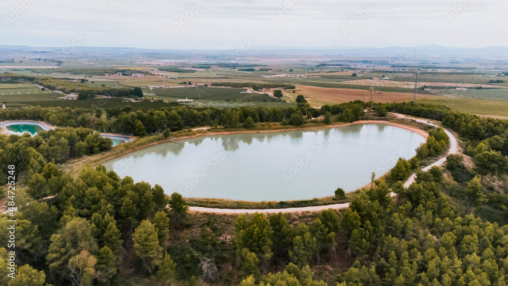 Aerial view of a lake surrounded by pine trees Aerial view of a lake surrounded by pine trees