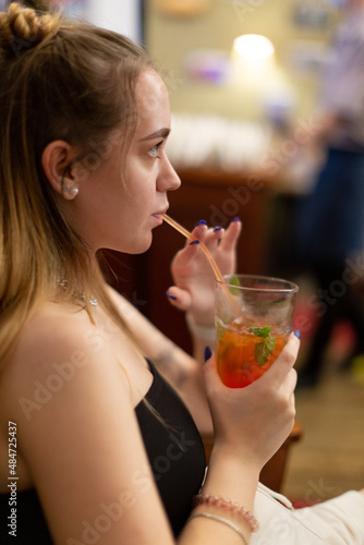 A young woman drinks lemonade through a straw