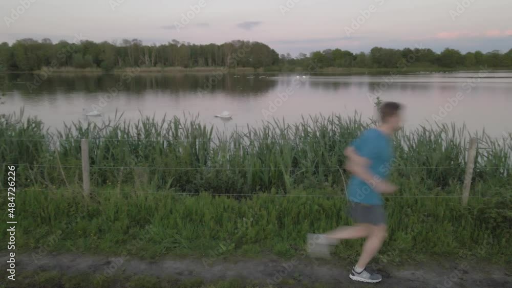 A man runs across the screen on a trail through the park A man runs across the screen on a trail through the park