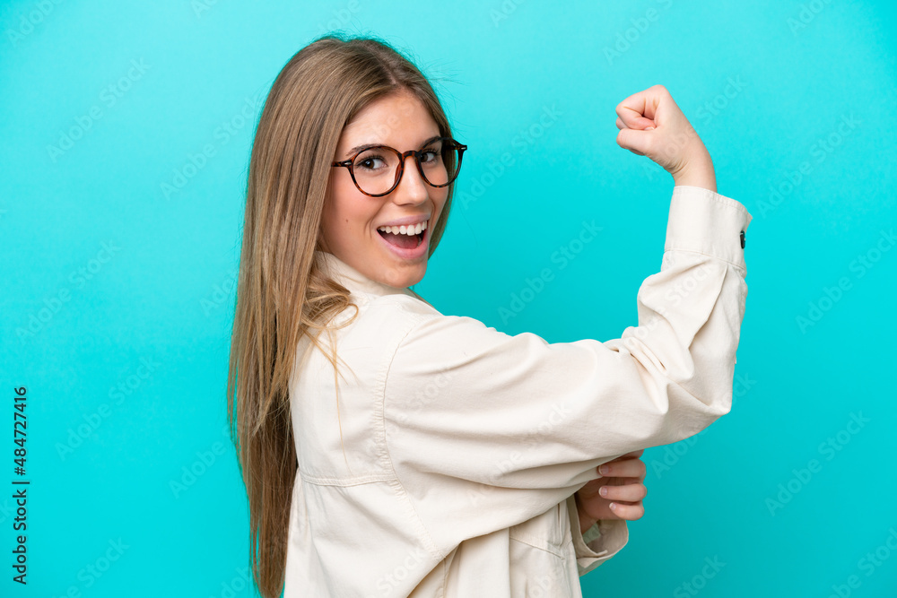 Young caucasian woman isolated on blue background With glasses and celebrating a victory Young caucasian woman isolated on blue background With glasses and celebrating a victory
