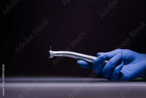 Fototapeta a dental tip and a metal bur in dentistry treats caries a blue gloved hand holds