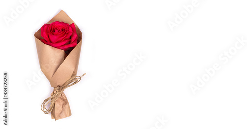 Bouquet one fresh red rose wrapped in kraft paper.