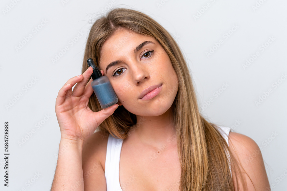 Young caucasian woman isolated on white background holding a serum. Close up portrait Young caucasian woman isolated on white background holding a serum. Close up portrait