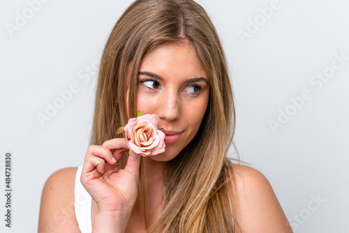 Young caucasian woman isolated on white background holding flowers. Close up portrait