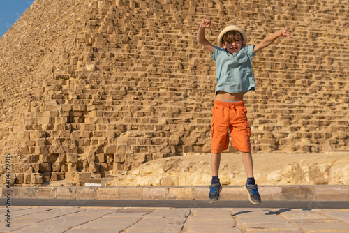 Happy boy jumping in front of the Cheops pyramid on the Giza plateau. © Igor