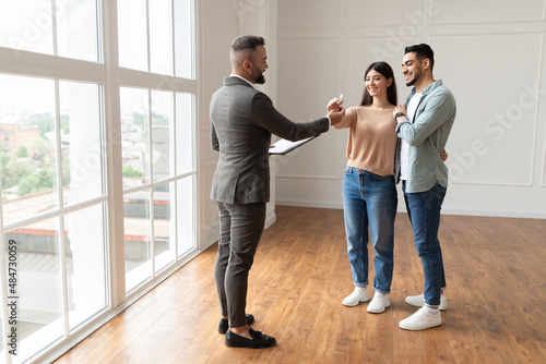 Real Estate Agent Giving Keys To Excited Buyers © Prostock-studio