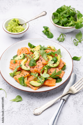 Fresh salmon salad with avocado, for keto and low carb diet. Rusty background, top view, copy space.