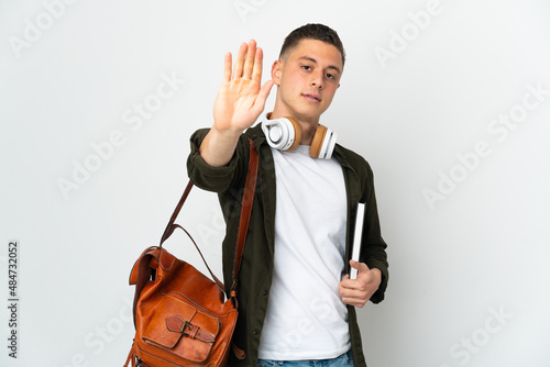 Young caucasian student man isolated on white background making stop gesture