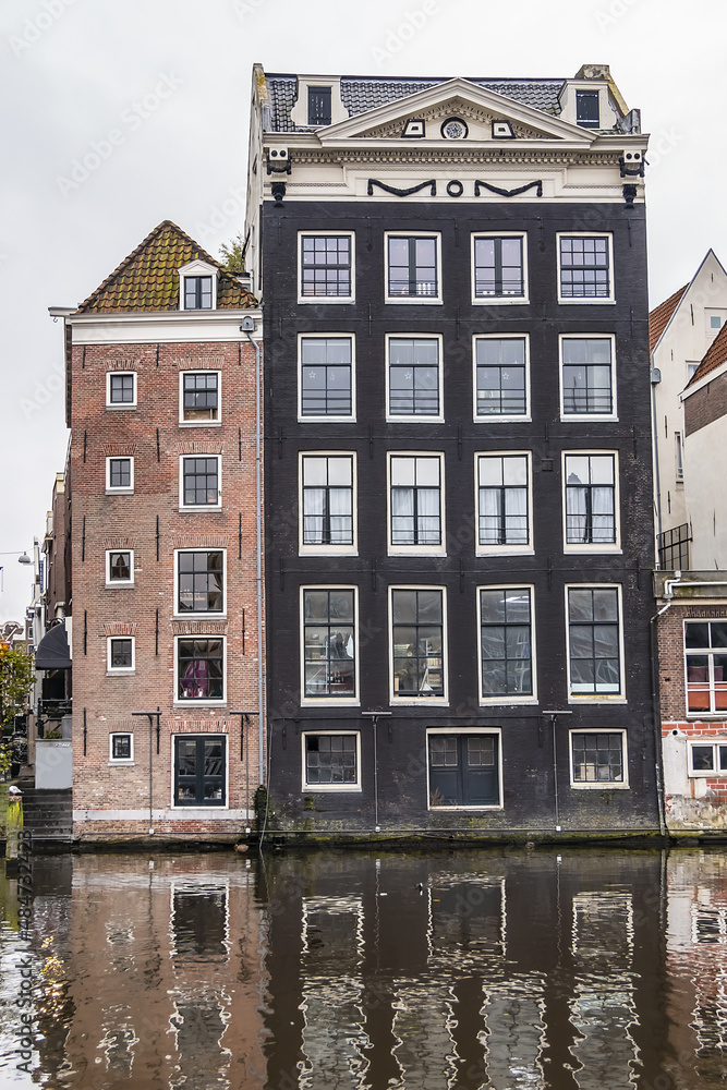 Damrak Waterfront: Typical old Dutch houses at Damrak water canal. Amsterdam, Netherlands.