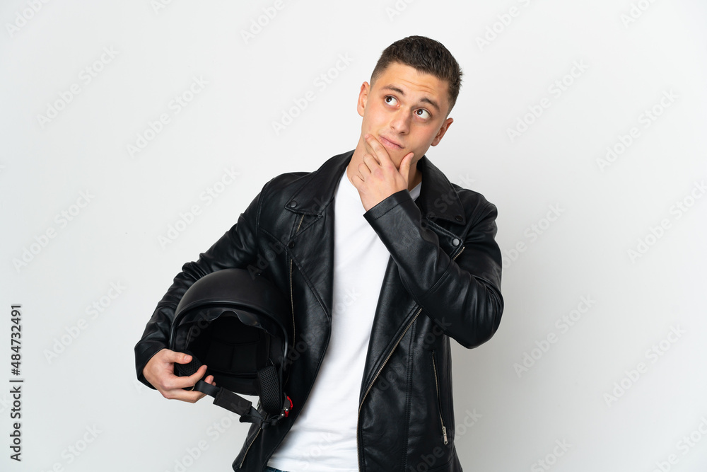 Caucasian man with a motorcycle helmet isolated on white background having doubts