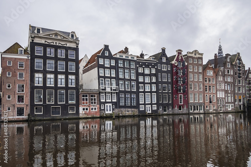 Damrak Waterfront: Typical old Dutch houses at Damrak water canal. Amsterdam, Netherlands.