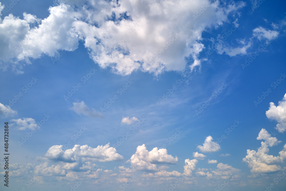 Bright landscape of white puffy cumulus clouds on blue clear sky Bright landscape of white puffy cumulus clouds on blue clear sky