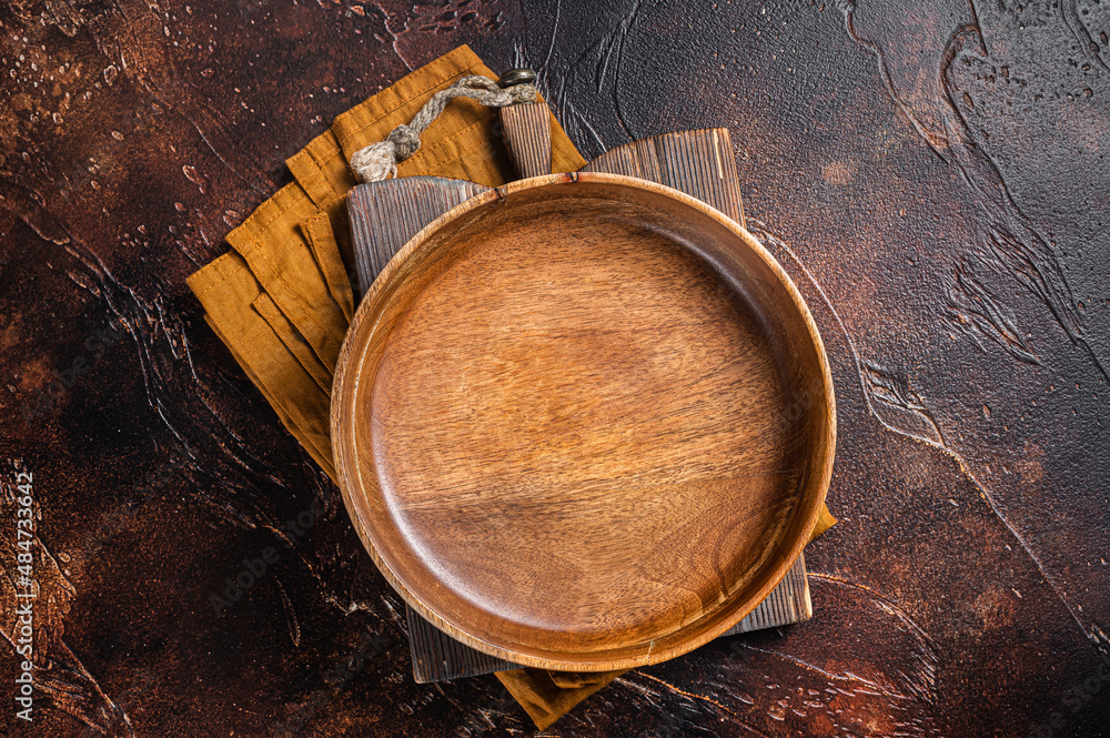 Table setting with vintage empty wooden plate on rustic wood. Dark background. Top view. Copy space