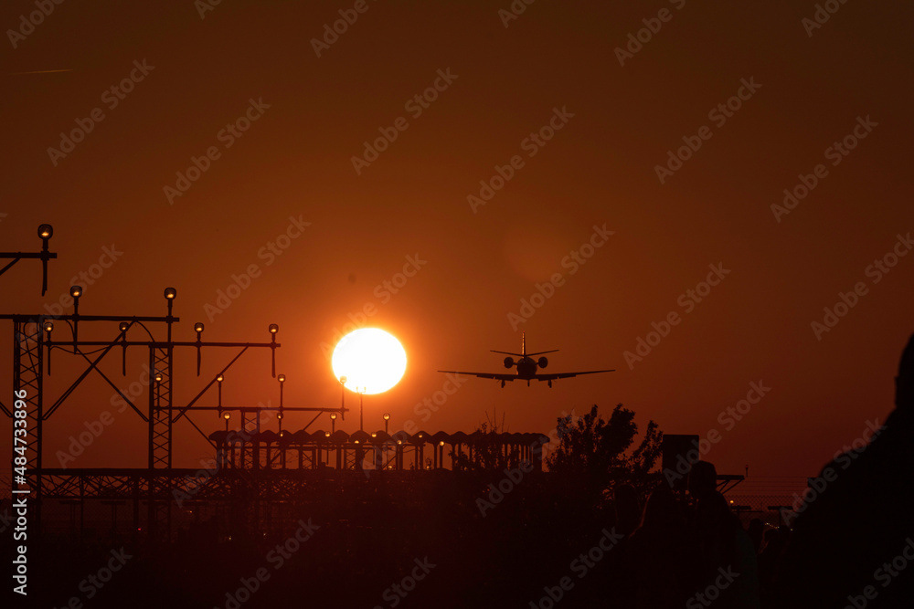 Airplane landing with the sun nearby