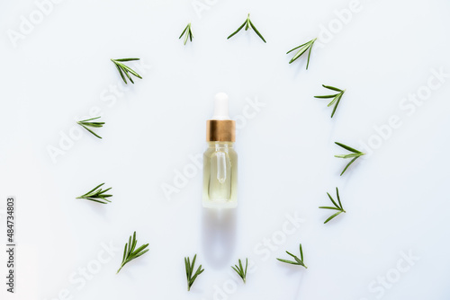 Green twigs and leaves of rosemary isolated on white background. Rosemary set, cosmetic oil. Flat lay. View from above.
