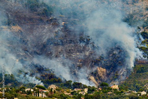 Fire in the forest mountain in the Italian town of Ventimiglia, all the mountains in the smoke, the villa is on fire, the fire service aircraft extinguish a fire photo