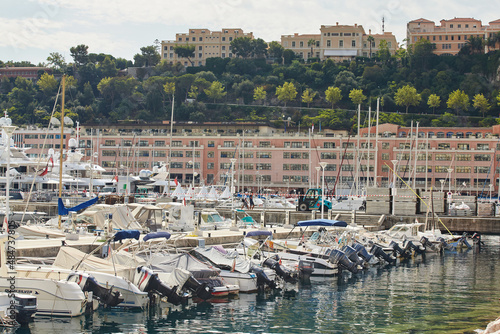 Monaco, Monte-Carlo, a lot of small motor boats are parked side by side in the port, with fenders between them to avoid collision at sunny day, mooring ropes go into the azure water © Vladimir Drozdin