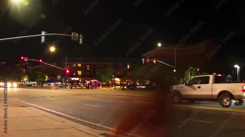 Time lapse of a street with cars driving and the traffic lights at night in a small town Time lapse of a street with cars driving and the traffic lights at night in a small town