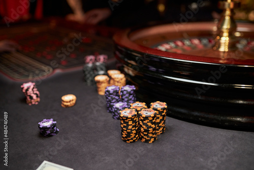 Multicolored casino table with roulette in motion, with multicolored casino chips. multi-colored poker chips. casino chips. online casino, poker, gambling. Gaming table